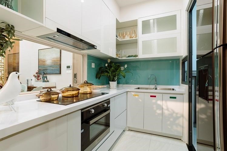 Thiết kế bếp đóng tránh mùi cho căn hộ, kết hợp mặt tường kính trong suốt quan sát được không gian bàn ăn và phòng khách bên ngoài